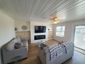 a living room with two couches and a flat screen tv at The Dunes in St. Augustine
