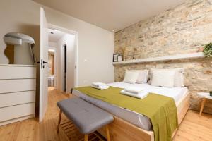 a bedroom with a bed and a stone wall at Petra Solis in Limenas