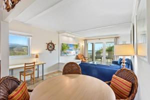 a living room with a table and chairs at DL104 - Dune's Watch in Nags Head