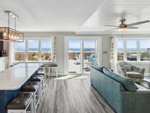 a kitchen and living room with a view of the ocean at 5055 - Sea La Vie in Avalon Bench