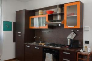 a kitchen with brown cabinets and a stove top oven at Parisi Cerese Borgo Virgilio a 5 minuti da Mantova in Virgilio