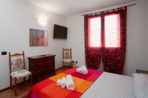 a bedroom with a bed with flip flops on it at Parisi Cerese Borgo Virgilio a 5 minuti da Mantova in Virgilio