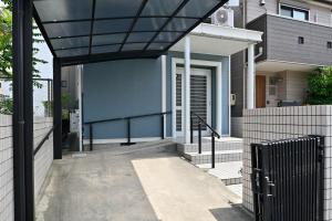 a modern house with a glass canopy over a driveway at Otter Stay - Nagoya Castle in Nagoya