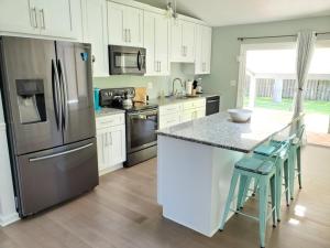 a kitchen with white cabinets and a stainless steel refrigerator at Floridays in Butler Beach