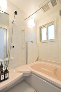 a bathroom with a pink tub and a window at Otter Stay - Nagoya Castle in Nagoya