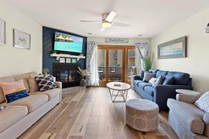 a living room with two couches and a tv at QCB5 - Saltaire Sunrise in Nags Head