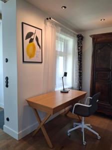 an office with a wooden desk and a chair at Villa Manna - Charming Flat in a Historic House in Tallinn