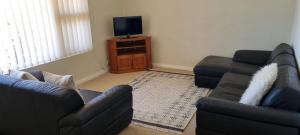 a living room with two couches and a television at River Cottage at Mannum in Mannum +12 photos