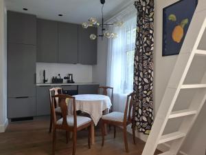 a kitchen with a table and chairs and a kitchen with a stair at Villa Manna - Charming Flat in a Historic House in Tallinn