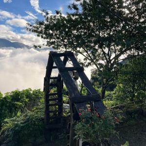 a wooden gate on a hill with clouds in the background at Lofi Homestay Tà Xùa in Bắc Yên