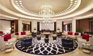 a lobby with a chandelier and a table and chairs at Hyatt Regency Istanbul Atakoy in Istanbul
