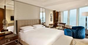 a bedroom with a white bed and a blue chair at Hyatt Regency Istanbul Atakoy in Istanbul