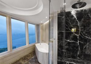 a bathroom with a tub and a glass shower stall at Hyatt Regency Istanbul Atakoy in Istanbul