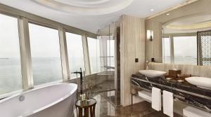 a bathroom with two sinks and a tub and windows at Hyatt Regency Istanbul Atakoy in Istanbul