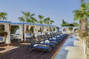 a row of chairs on a deck with palm trees at Hyatt Regency Istanbul Atakoy in Istanbul