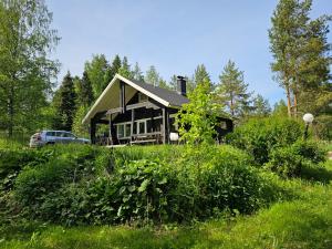 una casa sentada en la cima de un exuberante campo verde en Villa Tuliniemi, en Siilinjärvi