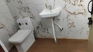 a bathroom with a toilet and a sink at Hotel O Malleshwaram in Bengaluru