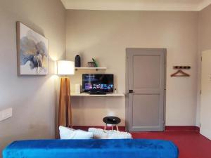 a room with a blue couch and a tv and a door at Terrazza San Martino San Gimignano Apartments in San Gimignano