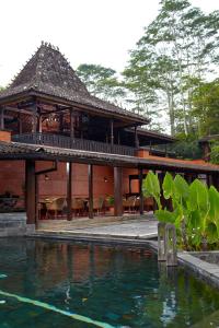 a building with a pool of water in front of it at MesaStila Resort and Spa in Borobudur