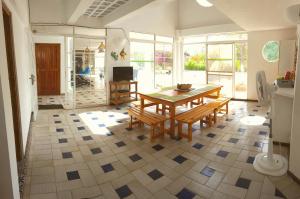 a dining room with a table and benches on a tile floor at Coral House San Andres in San Andrés
