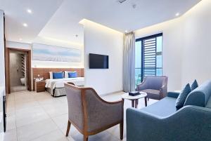 a hotel room with a bed and a living room at Wyndham Garden Ajman Corniche in Ajman 