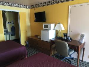 a hotel room with a desk with a computer and a microwave at Norwalk Inn in Norwalk