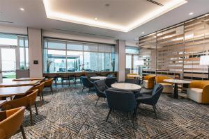 比福德Homewood Suites By Hilton Buford Mall Of Ga的有桌椅和窗户的餐厅