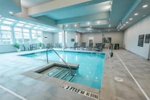 比福德Homewood Suites By Hilton Buford Mall Of Ga的大型客房的大型游泳池,配有桌椅