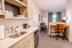 比福德Homewood Suites By Hilton Buford Mall Of Ga的厨房配有水槽和桌椅