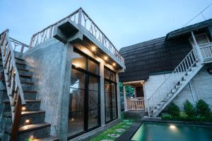 an external view of a house with a pool and stairs at Vila Buruan in Mantaak