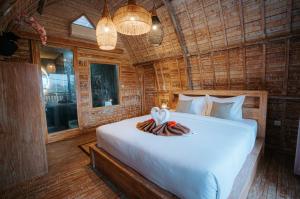 a bedroom with a bed in a wooden room at Vila Buruan in Mantaak