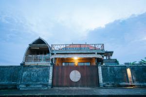 a building with a gate with a clock on it at Vila Buruan in Mantaak +8 photos