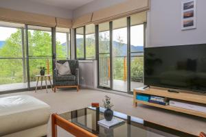 sala de estar con TV de pantalla grande y sofá en Valley Vista, en Bright