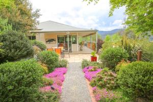 una casa con un jardín con flores rosas en Valley Vista, en Bright