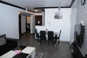 a living room with a table and chairs at Arinza Tower Quality Apartments in Kuwait