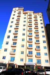 a large building with cars parked in front of it at Arinza Tower Quality Apartments in Kuwait