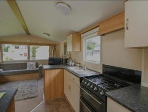 a kitchen with a sink and a stove top oven at Caravan 3 - Blackmoor farm near Tenby in Ludchurch