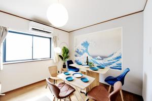 una sala de estar con una mesa y sillas en Tsumugu art base, en Osaka