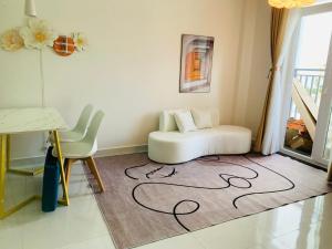 a living room with a white couch sitting on a rug at NY House Hacome 2BR Center Phan Rang in Kinh Dinh