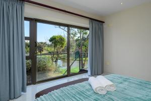 サウスブルームにあるSan Lameer Villa 14209 - 4 Bedroom Deluxe - 8 pax - San Lameer Rental Agencyのベッドと大きな窓のある寝室