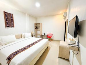 a hotel room with a bed and a tv at Mama Komodo Bed & Breakfast in Komodo Labuan Bajo Airport