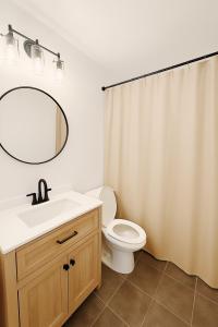 a bathroom with a sink and a toilet with a mirror at Hale Moana Retreat AC Walk to Ocean and Spacious Family Stay in Laie +16 photos