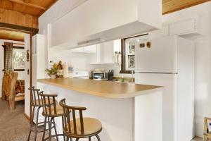 a kitchen with white cabinets and bar stools at Holmes Away From Home #2485 in Sugarloaf +17 photos
