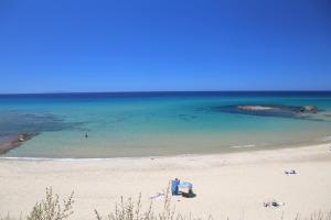 uma praia com um grupo de pessoas e o oceano em Hotel Residence Ampurias em Castelsardo