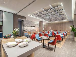 a dining room with tables and chairs in a restaurant at Country Inn & Suite by Radisson, Shanghai Hongkou Football Stadium Chifeng Road in Shanghai