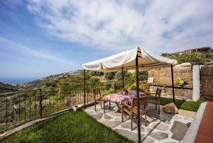 ein Tisch und Stühle unter einem Sonnenschirm auf einer Terrasse in der Unterkunft Holiday home in Pompeiana 40835 in Pompeiana