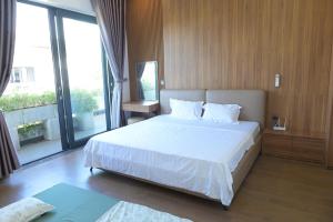 une chambre avec un lit blanc et une grande fenêtre dans l'établissement Peace Villa, à Dong Quan