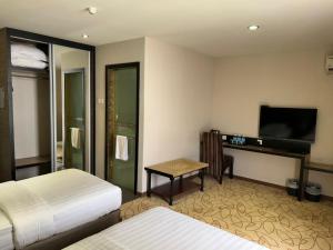 a hotel room with two beds and a flat screen tv at Milano Hotel in Kluang