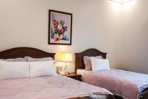a bedroom with two beds and a picture on the wall at Pearl Hotel Ha Long in Ha Long +27 photos