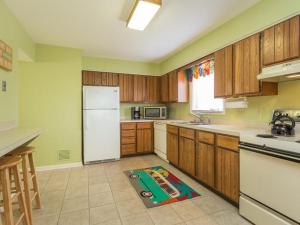 a kitchen with wooden cabinets and a white refrigerator at Swedes street 201 in Dewey Beach